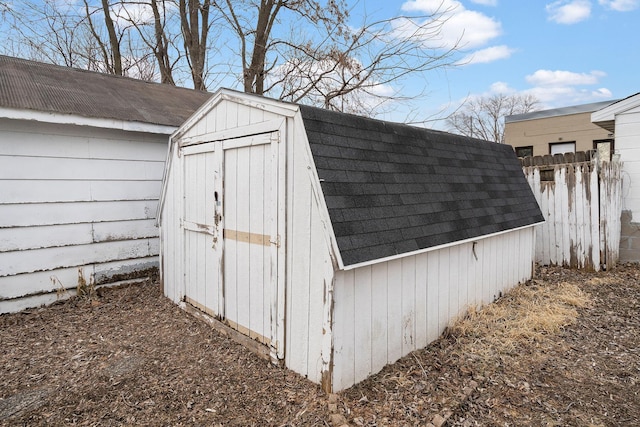 view of shed featuring fence