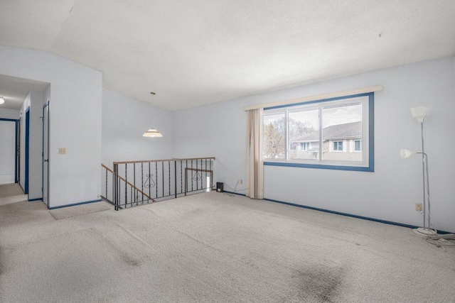 empty room featuring carpet flooring and lofted ceiling