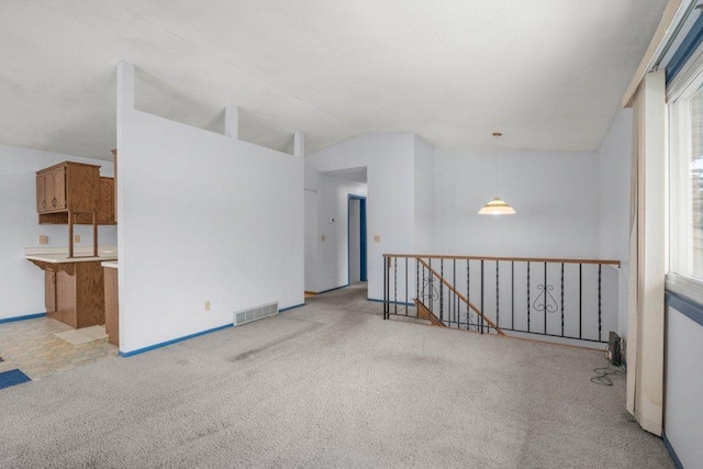 unfurnished room featuring light carpet, visible vents, and lofted ceiling