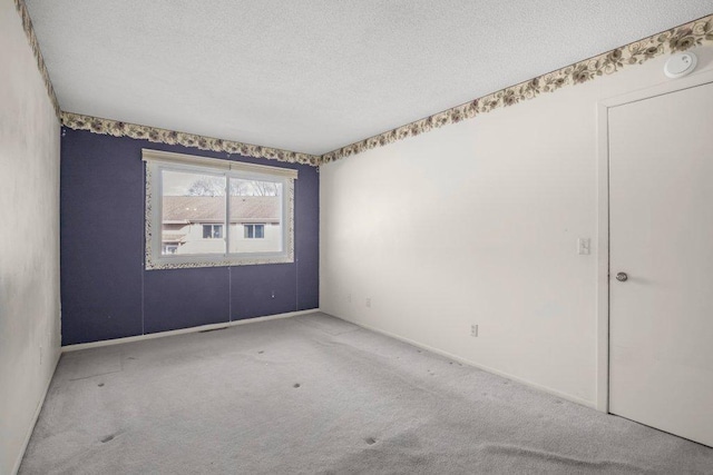 carpeted spare room featuring a textured ceiling