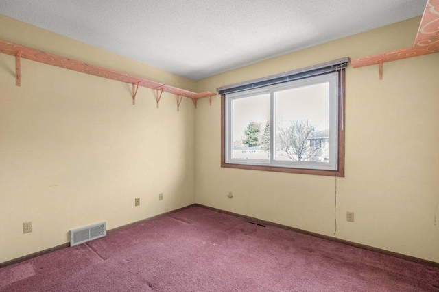 empty room with visible vents, baseboards, a textured ceiling, and carpet flooring