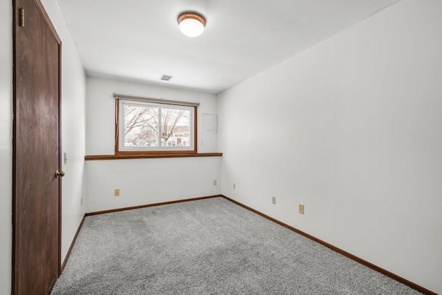 carpeted spare room with visible vents and baseboards