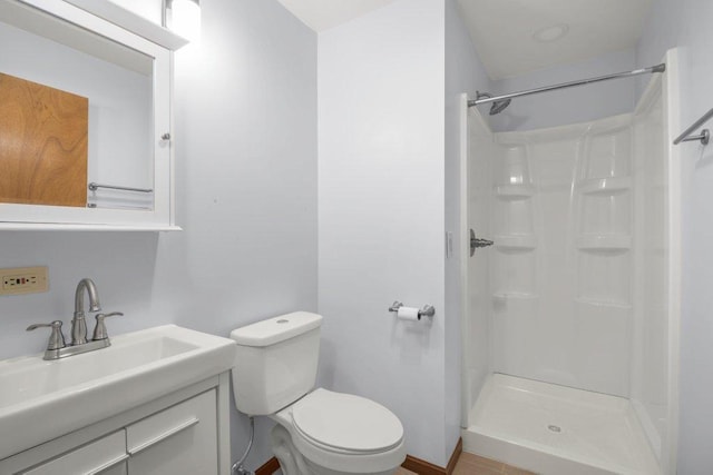 bathroom with a stall shower, toilet, and vanity