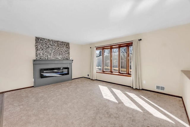 unfurnished living room with carpet floors, visible vents, and baseboards