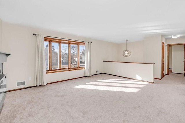 unfurnished living room with baseboards, visible vents, a notable chandelier, and carpet flooring