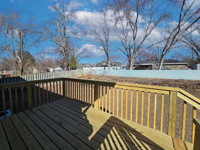 wooden terrace with a fenced backyard