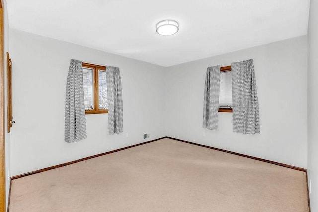 carpeted spare room featuring baseboards