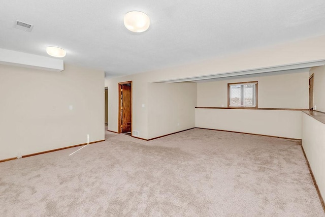 carpeted spare room with visible vents, a textured ceiling, and baseboards