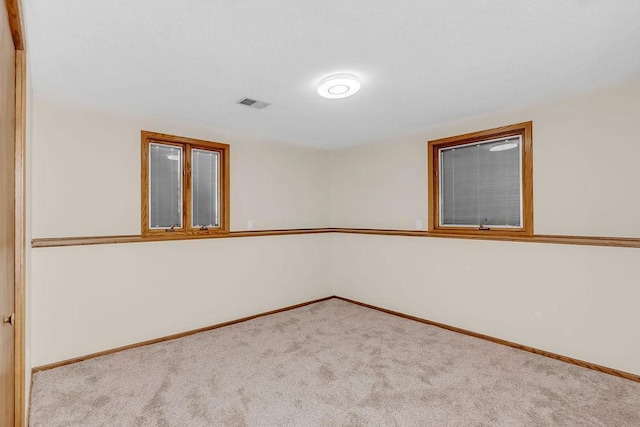 unfurnished room with carpet flooring, visible vents, and baseboards