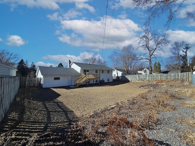 rear view of property with a fenced backyard and a chimney