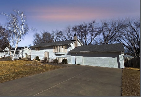 view of front of house with concrete driveway and an attached garage