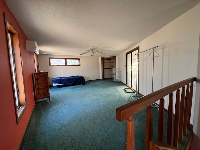 21888 650th Ave, Dexter, MN 55926 - unfurnished bedroom with carpet, a wall unit AC, a ceiling fan, and a textured ceiling