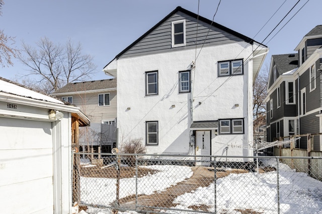 view of front of home with stucco siding and fence