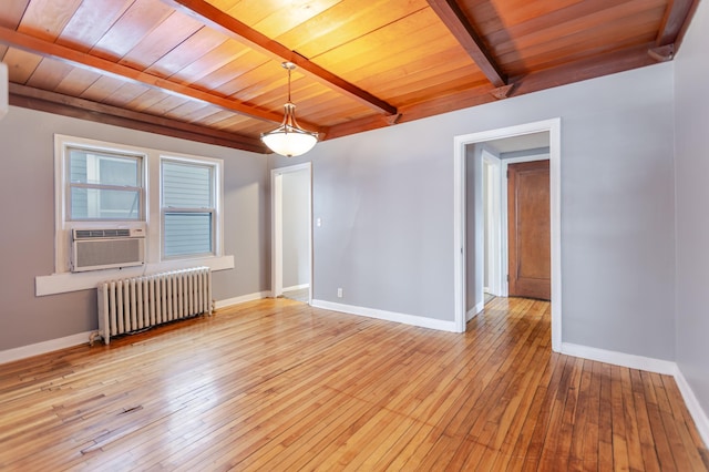 empty room featuring beam ceiling, light wood-style flooring, radiator, and baseboards