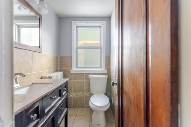 bathroom with vanity, a wainscoted wall, tile patterned floors, toilet, and tile walls