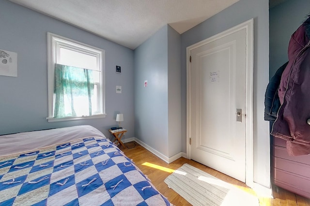 bedroom featuring baseboards and wood finished floors