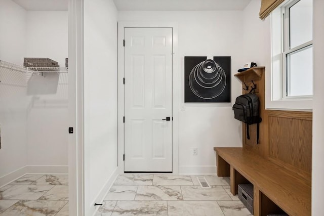 mudroom featuring marble finish floor and baseboards