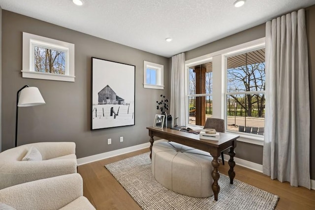 office space with a textured ceiling, recessed lighting, wood finished floors, and baseboards