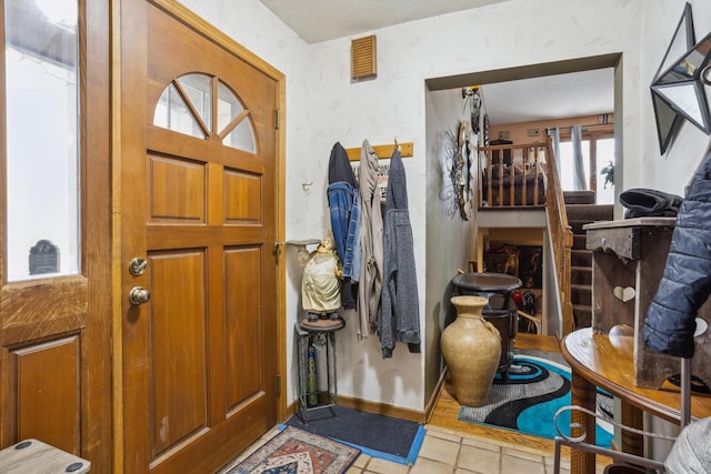 entrance foyer featuring tile patterned flooring, visible vents, and baseboards