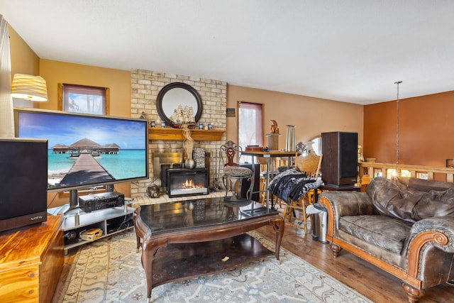 living room with a fireplace and wood finished floors