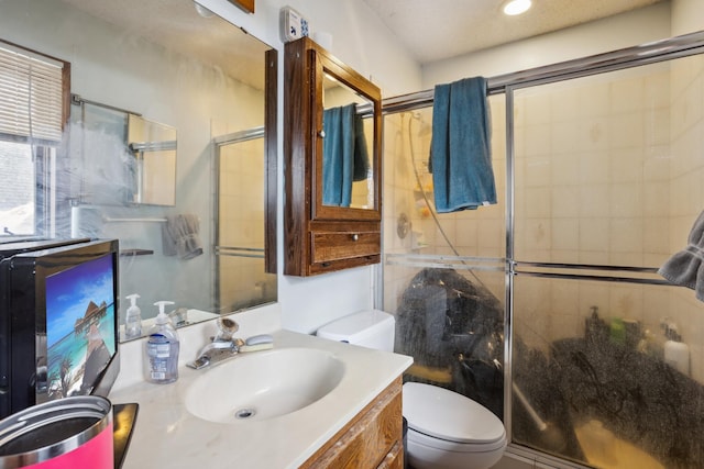 full bath featuring toilet, a shower stall, and vanity