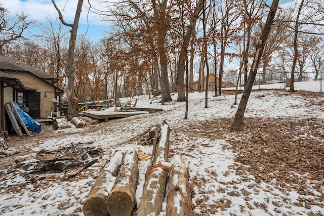 snowy yard with fence and a deck