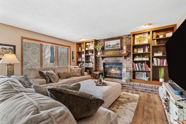 living area featuring a fireplace, a textured ceiling, and wood finished floors