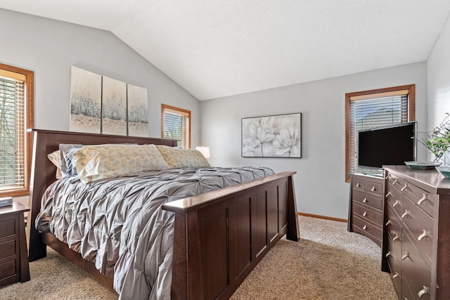 bedroom with light colored carpet, baseboards, and lofted ceiling