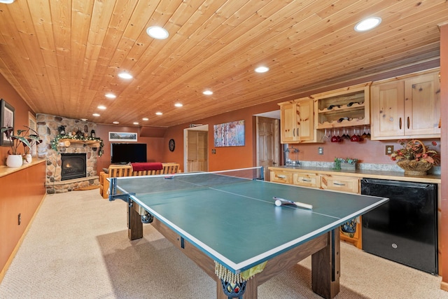 playroom featuring recessed lighting, carpet, a stone fireplace, and wooden ceiling
