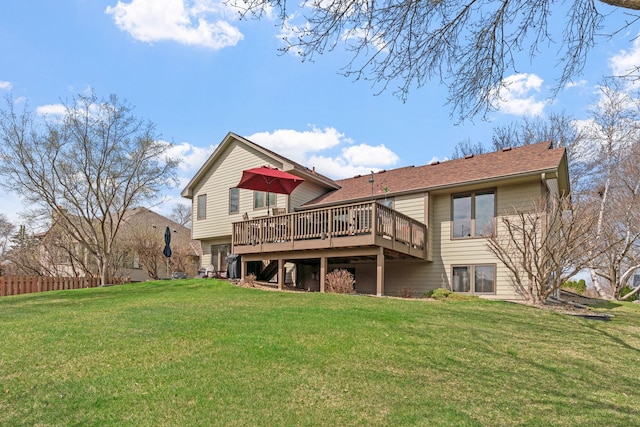 rear view of house with fence, a shingled roof, a yard, and a deck