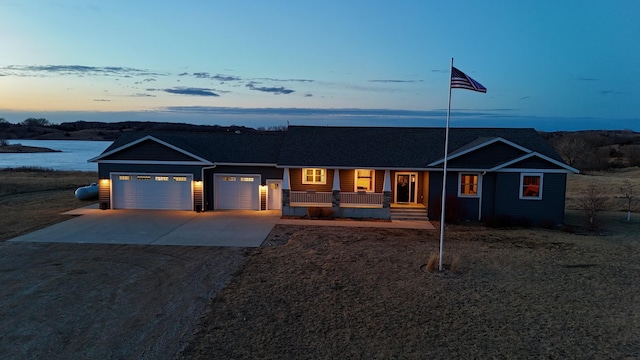 ranch-style house featuring covered porch, concrete driveway, and an attached garage