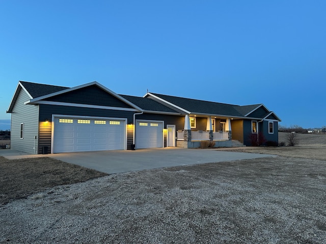 ranch-style home with a garage, covered porch, and driveway