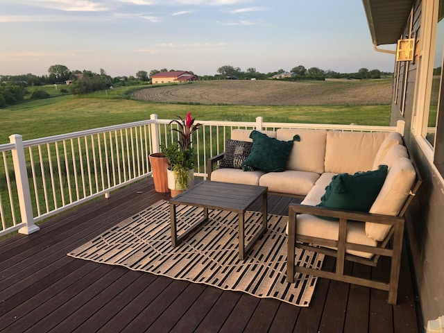 wooden deck with a rural view and outdoor lounge area