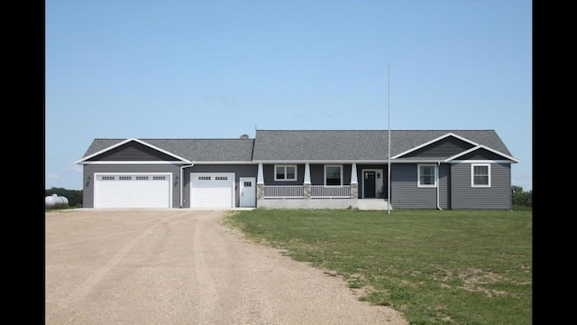 ranch-style home featuring a garage, a front yard, a porch, and dirt driveway