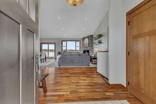 hall with recessed lighting, baseboards, high vaulted ceiling, and light wood finished floors