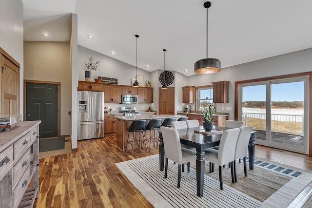 dining area featuring recessed lighting, wood finished floors, and high vaulted ceiling