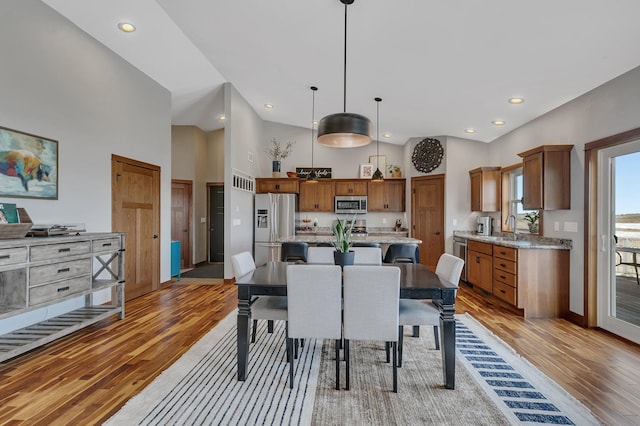 dining space featuring recessed lighting, light wood-type flooring, and high vaulted ceiling