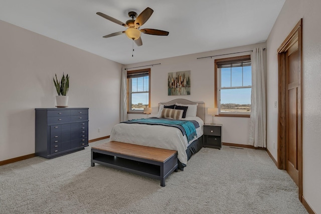 bedroom featuring baseboards, light carpet, and ceiling fan