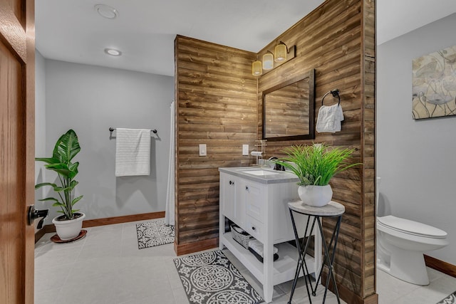 full bathroom with rustic walls, toilet, vanity, and baseboards