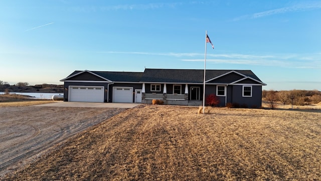 single story home featuring a garage, a porch, and driveway