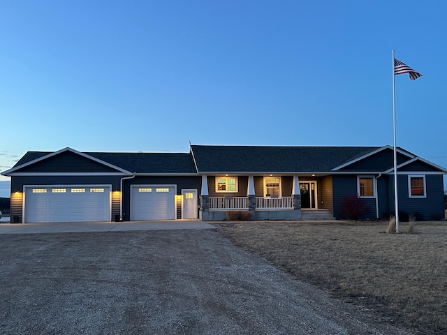 single story home featuring a porch, an attached garage, and driveway