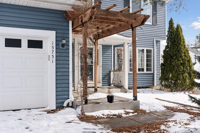 snow covered property entrance featuring a pergola and a garage