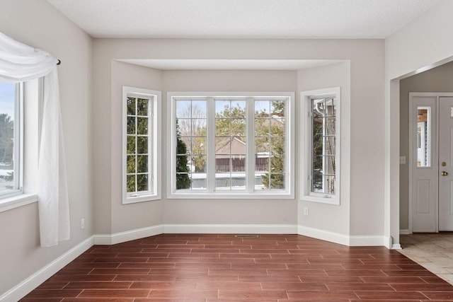 interior space with dark wood-style floors, visible vents, and baseboards