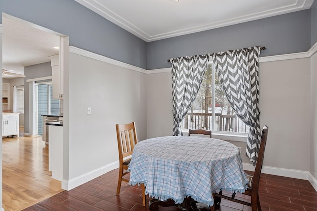 dining space featuring wood finished floors and baseboards