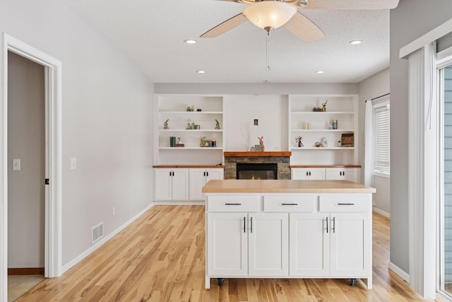 kitchen featuring white cabinetry, open shelves, visible vents, and light wood-type flooring