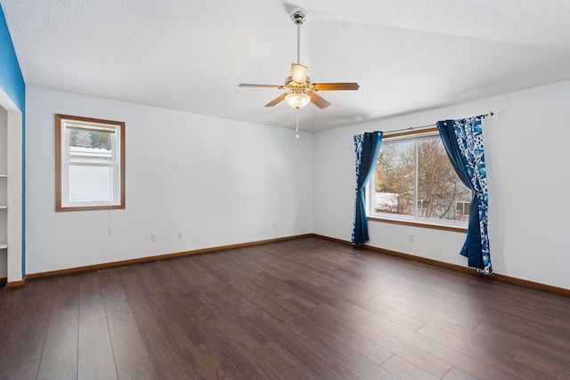 unfurnished room featuring dark wood-style floors, plenty of natural light, and a textured ceiling