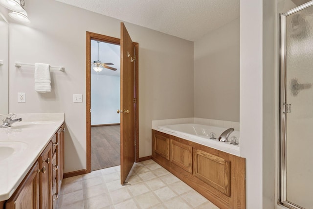 bathroom featuring double vanity, a stall shower, a bath, a textured ceiling, and a sink