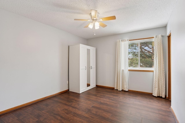 unfurnished bedroom featuring dark wood-style floors, baseboards, and a textured ceiling