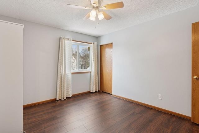 unfurnished room featuring baseboards, a textured ceiling, dark wood-style floors, and a ceiling fan