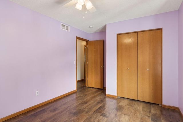 unfurnished bedroom featuring a closet, visible vents, baseboards, and wood finished floors